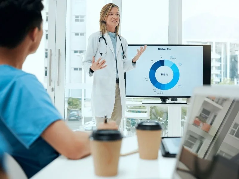 Clinician presenting performance results to a team in a meeting room