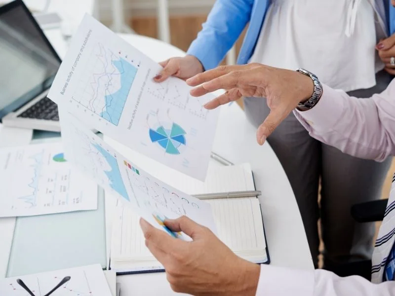 Team reviewing printed marketing charts and reports