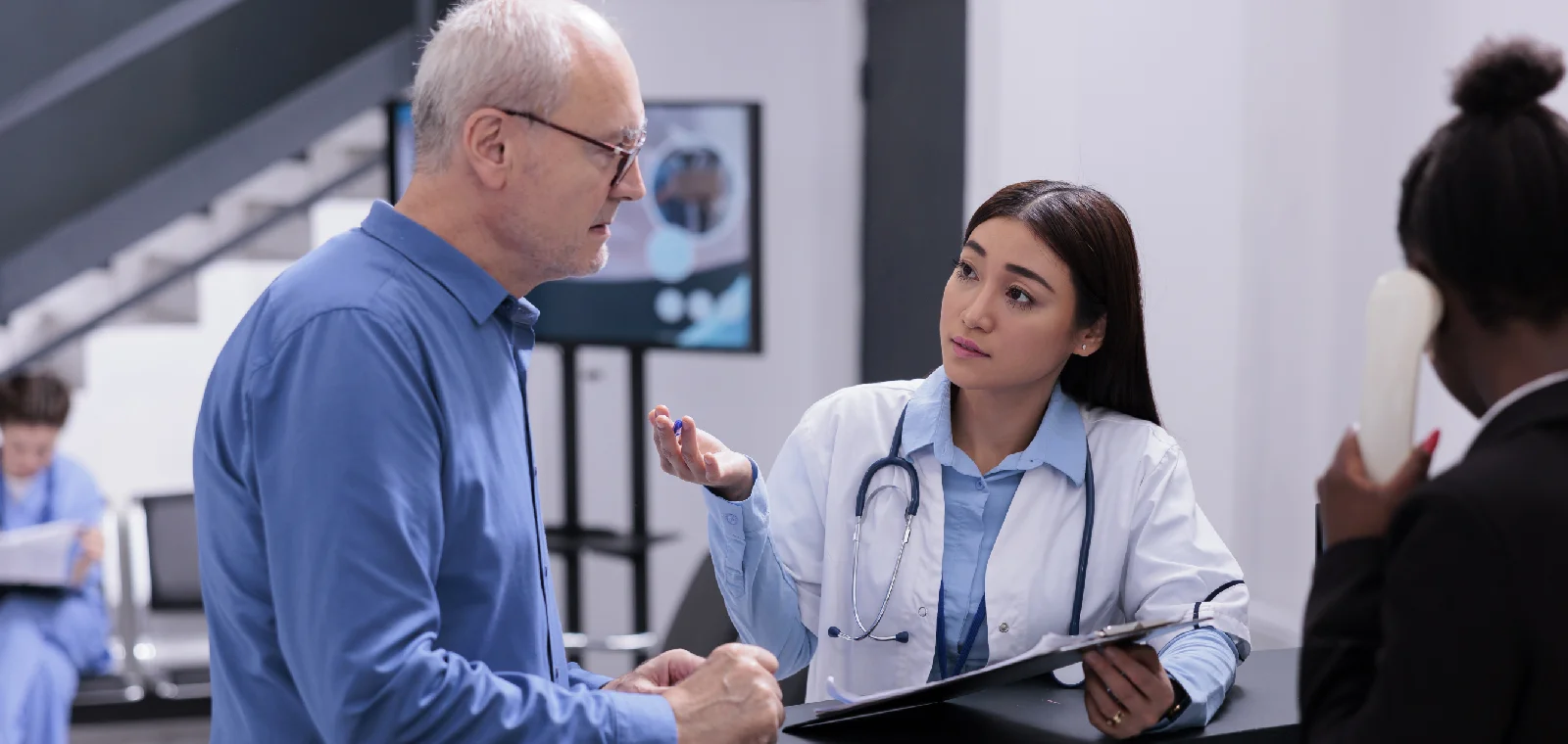 Clinic staff discussing a follow-up appointment with a patient at reception