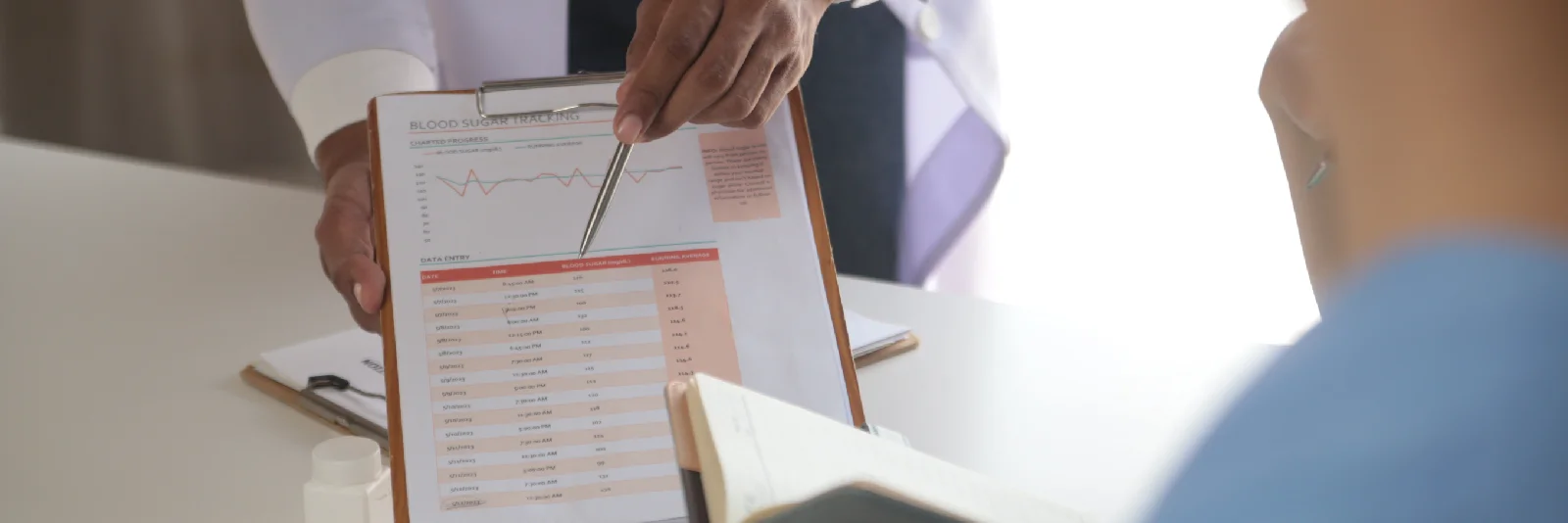 Clinician reviewing a patient's ongoing progress chart during a recall visit