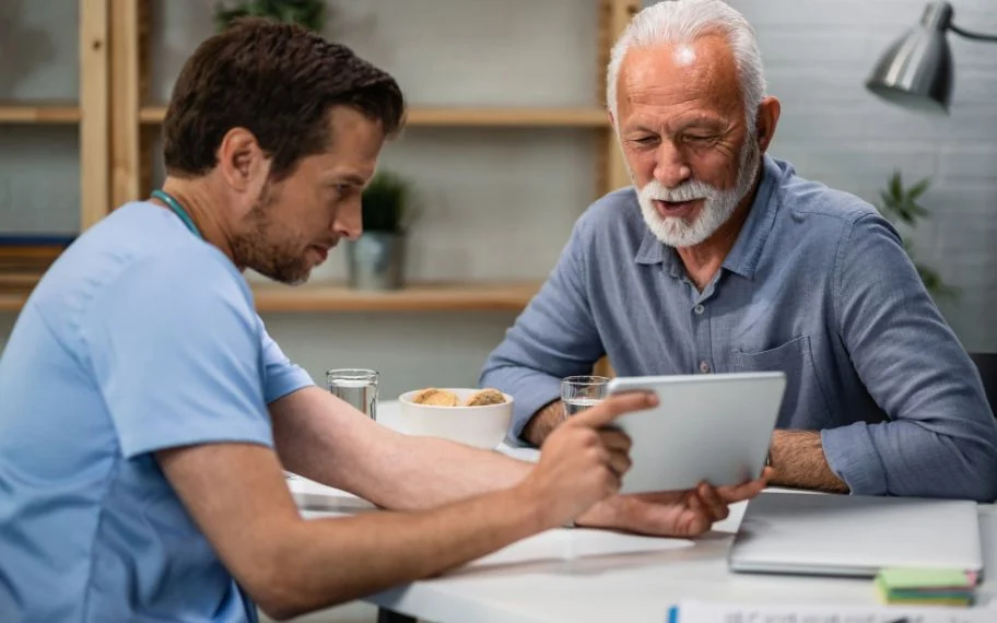 Staff member reviewing information on a tablet with a patient