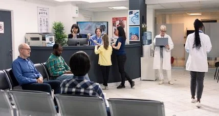 Busy urgent care waiting room with patients and staff